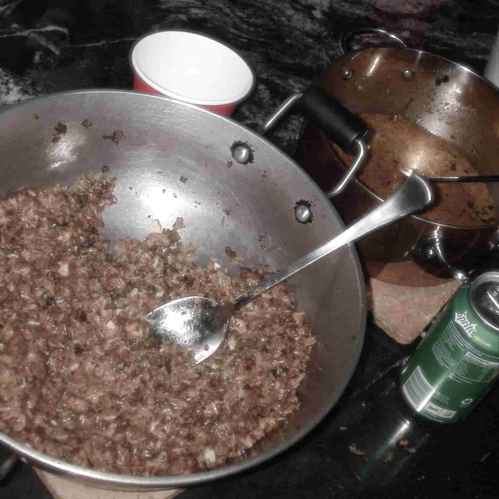 a pot of food surrounded by some cups and cans and a smaller pot with curry