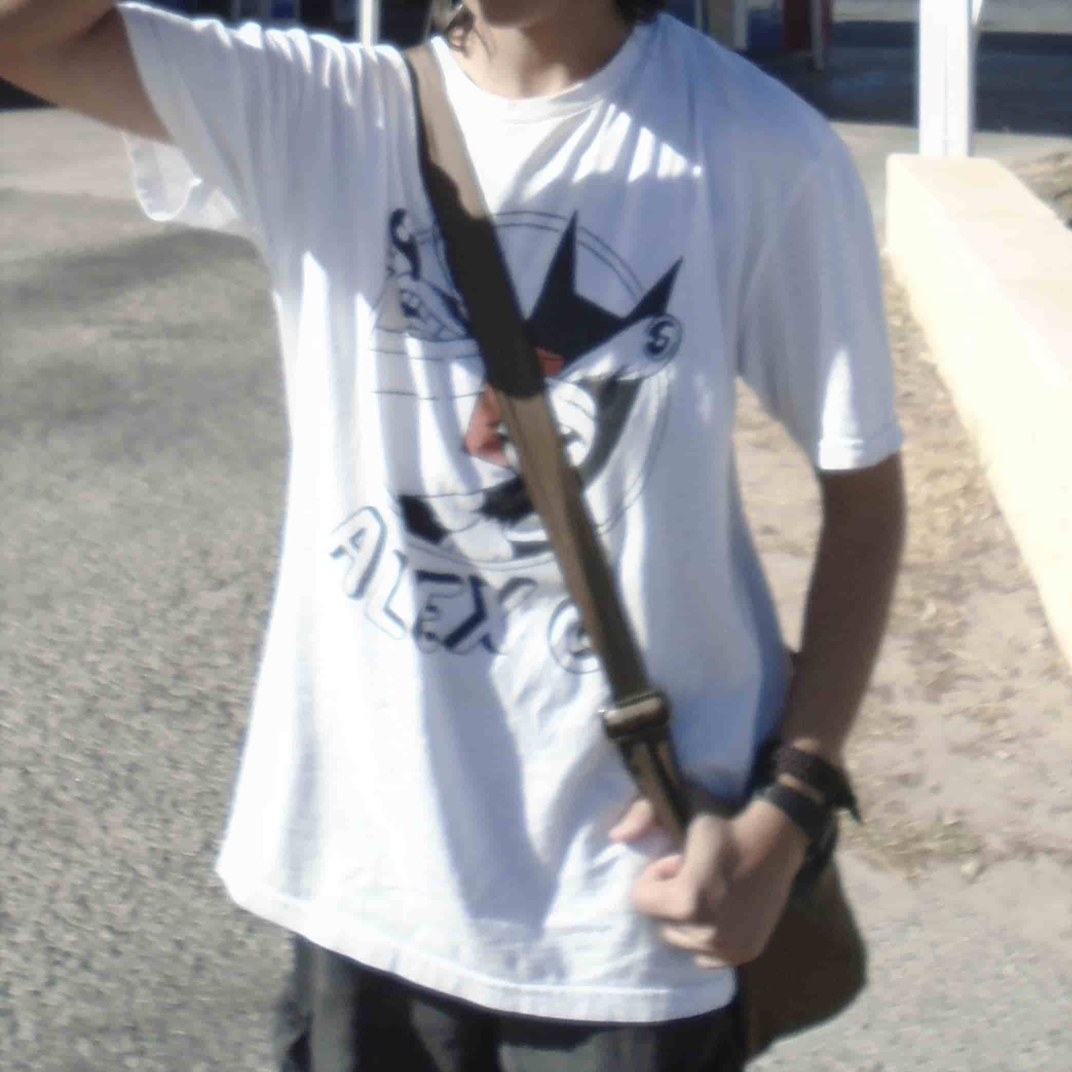 the torso of a person standing with a bag strap horizontal across his chest, his left arm holding the strap and his right arm raised